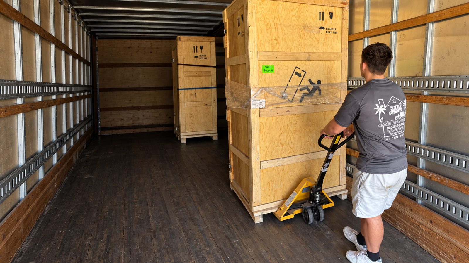 Mama Boy Movers professional moving a large crated specialty item inside a truck